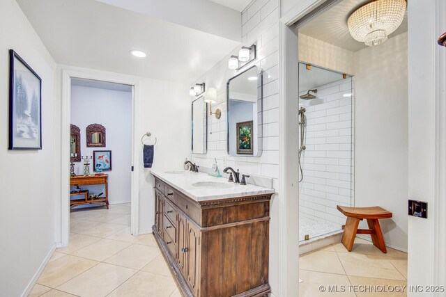 bathroom with tile patterned flooring, vanity, and tiled shower