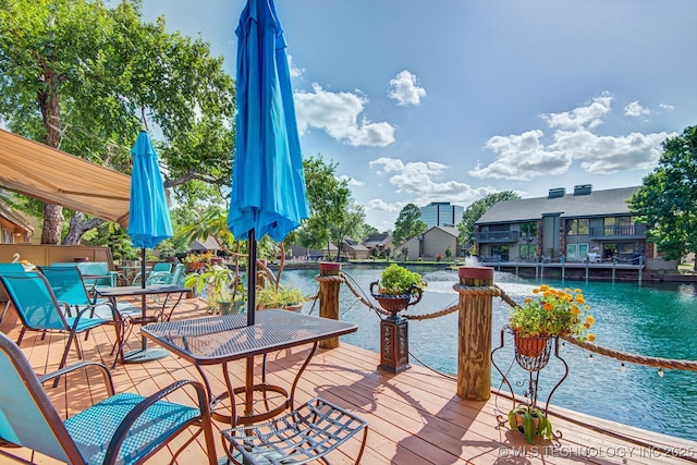 deck featuring outdoor dining area and a water view