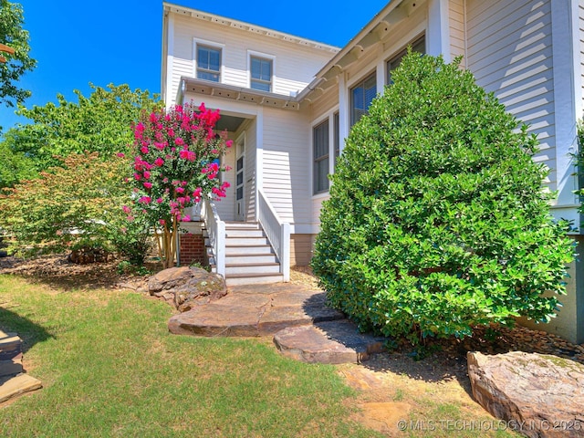 entrance to property featuring a lawn