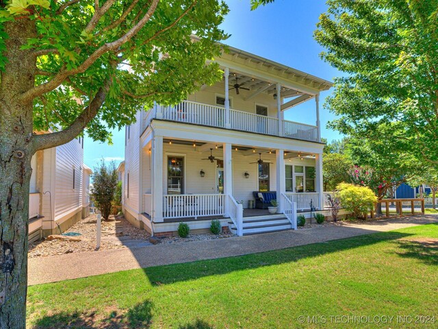 view of front facade featuring a balcony, a front lawn, a porch, and a ceiling fan