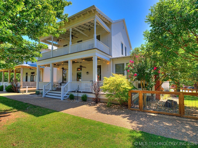 view of front of property with a balcony, covered porch, a front yard, and ceiling fan