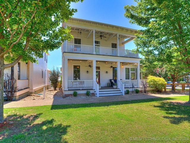 view of front of property with covered porch, ceiling fan, a balcony, and a front lawn