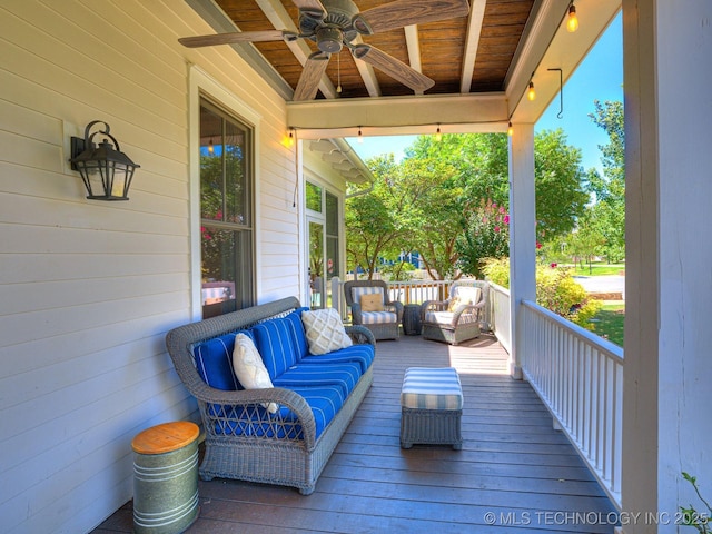 wooden terrace featuring a ceiling fan and an outdoor living space