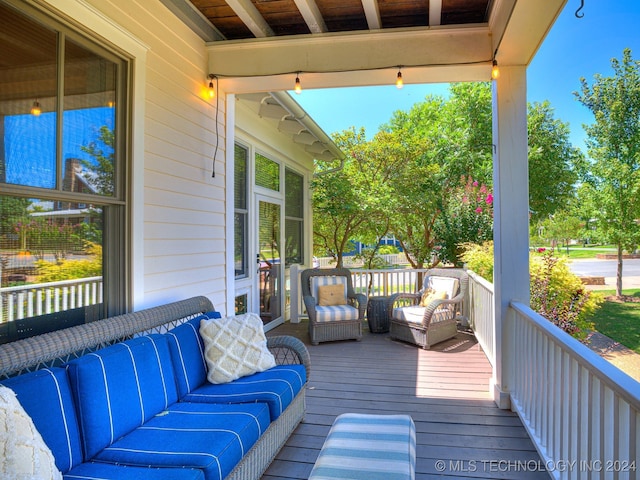 wooden terrace with an outdoor living space