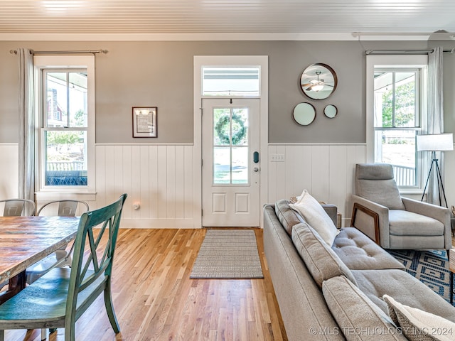 interior space with ornamental molding, plenty of natural light, and light wood-type flooring