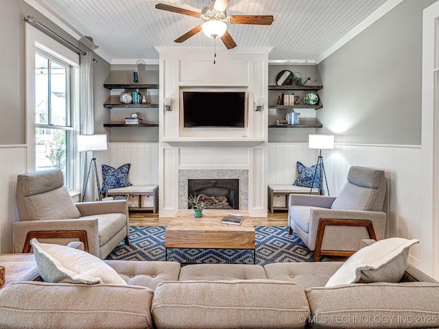 living area with ornamental molding, wainscoting, wood finished floors, and wood ceiling