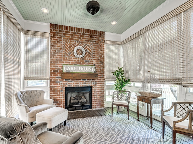 living room featuring a wealth of natural light, ornamental molding, a fireplace, and light hardwood / wood-style floors