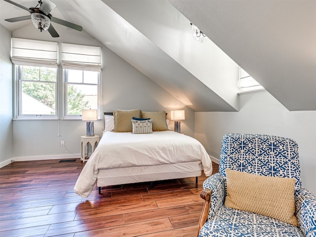 bedroom featuring hardwood / wood-style floors, vaulted ceiling, and ceiling fan