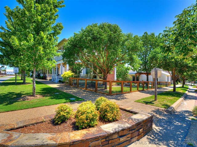 view of property's community with a fenced front yard and a lawn