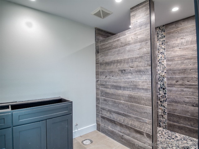 bathroom with tile patterned floors and tiled shower