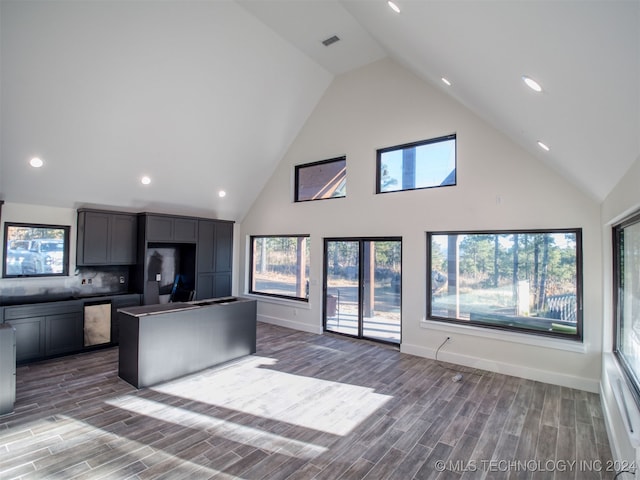 kitchen with backsplash, high vaulted ceiling, dark hardwood / wood-style floors, and a kitchen island