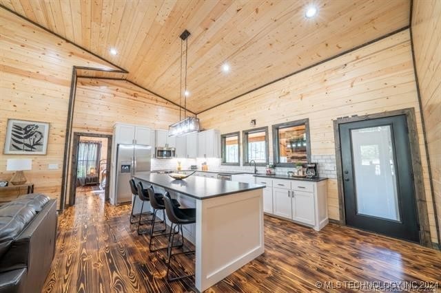 kitchen with white cabinetry, a center island, stainless steel appliances, and dark wood-type flooring