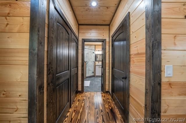 hall featuring hardwood / wood-style floors and wooden walls