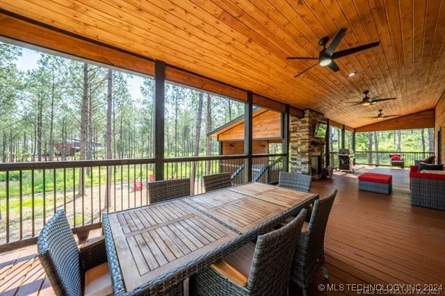 sunroom featuring wood ceiling, a healthy amount of sunlight, ceiling fan, and vaulted ceiling