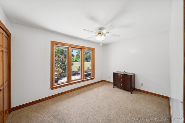 unfurnished bedroom with ceiling fan, light colored carpet, and a closet