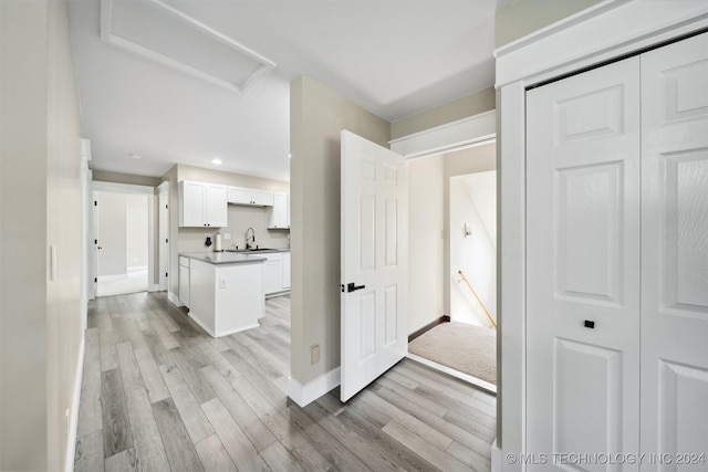 hallway with sink and light wood-type flooring