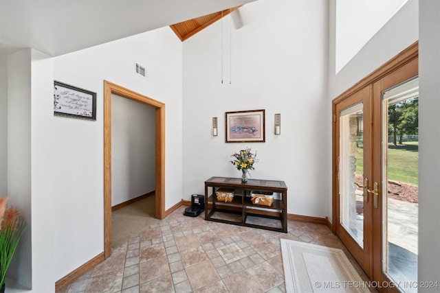 foyer featuring french doors and high vaulted ceiling