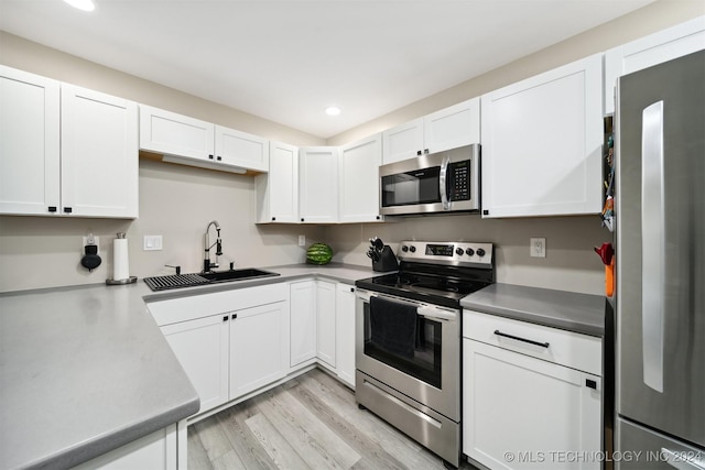 kitchen featuring white cabinetry, sink, stainless steel appliances, and light hardwood / wood-style floors