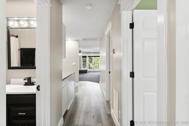 corridor featuring wood-type flooring and sink