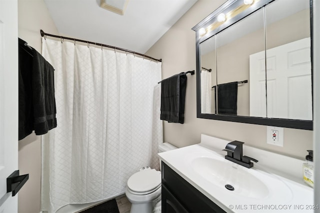 bathroom with vanity, vaulted ceiling, and toilet