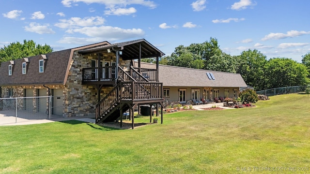 rear view of property with a yard, a patio area, and a deck