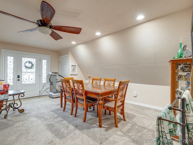 dining area featuring light carpet, ceiling fan, and vaulted ceiling