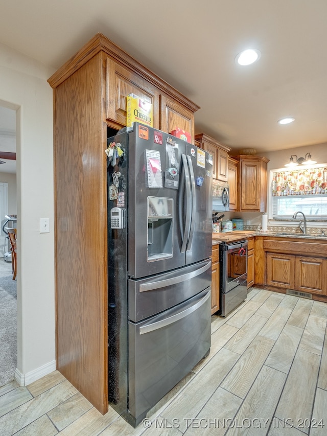 kitchen featuring light carpet, appliances with stainless steel finishes, and sink