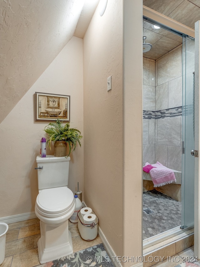 bathroom featuring an enclosed shower, tile patterned flooring, lofted ceiling, and toilet