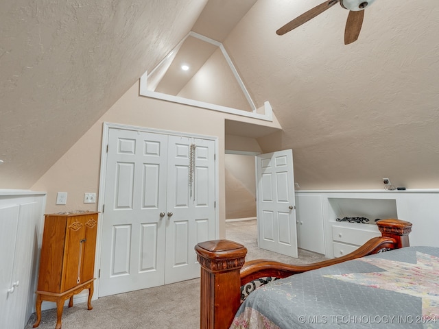 bedroom with light colored carpet, a closet, lofted ceiling, and ceiling fan