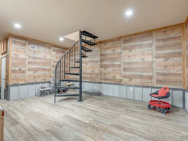 interior space with wood walls and hardwood / wood-style flooring