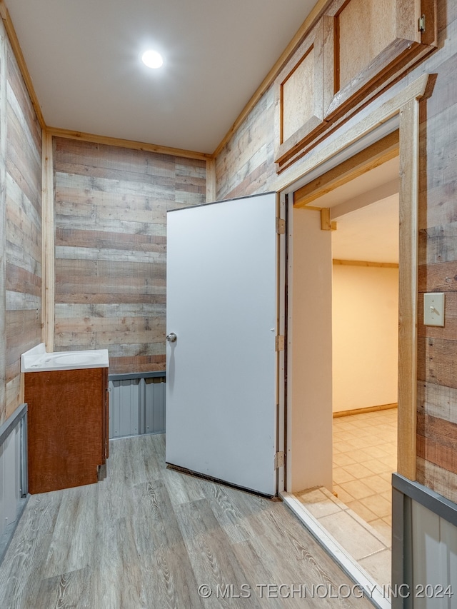 interior space with light hardwood / wood-style flooring and wooden walls