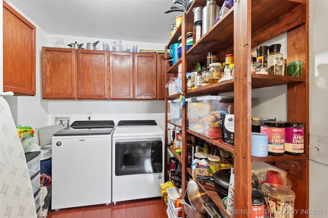 washroom with dark wood-type flooring, separate washer and dryer, and cabinets