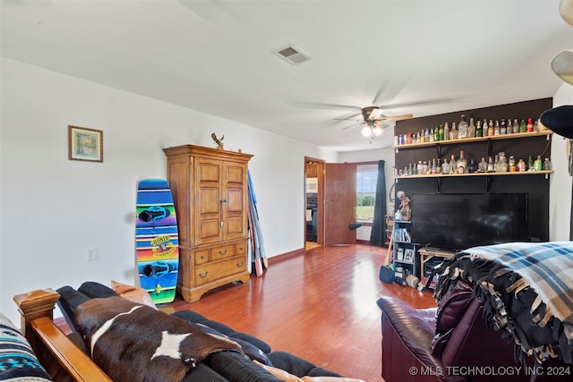 living room with dark hardwood / wood-style flooring and ceiling fan