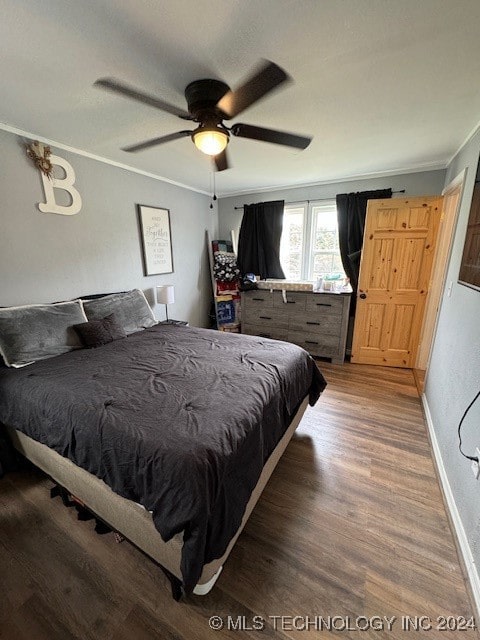 bedroom featuring hardwood / wood-style floors, ornamental molding, and ceiling fan