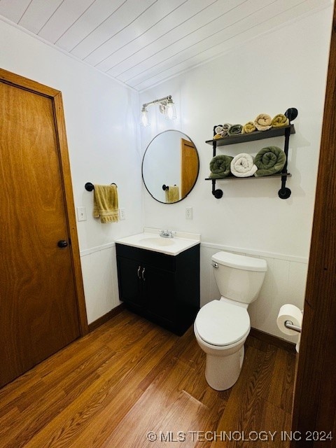 bathroom with wood-type flooring, toilet, and vanity