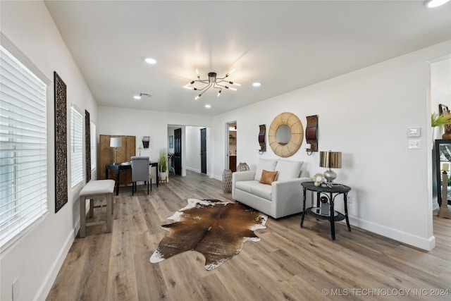 living room featuring light wood-type flooring and a notable chandelier