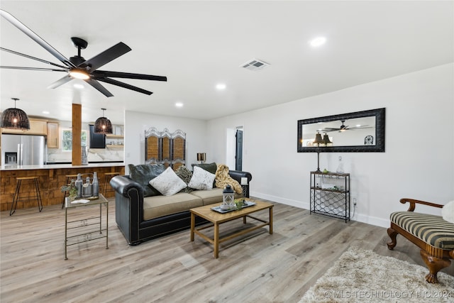 living room featuring light hardwood / wood-style flooring and ceiling fan