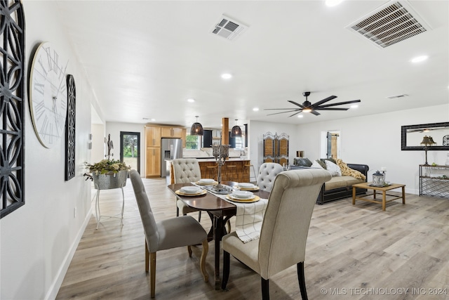 dining room with ceiling fan and light wood-type flooring