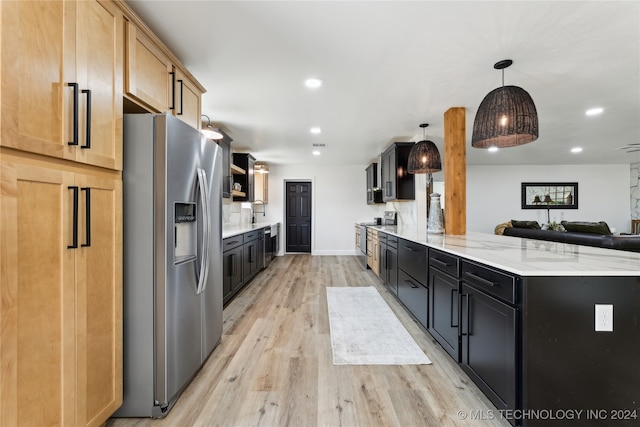 kitchen with light hardwood / wood-style flooring, stainless steel appliances, light stone counters, light brown cabinets, and decorative light fixtures