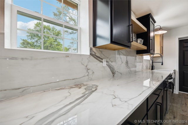 kitchen with decorative backsplash, dark hardwood / wood-style flooring, and light stone counters