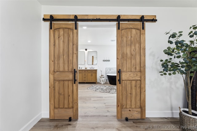 hallway with hardwood / wood-style flooring and a barn door