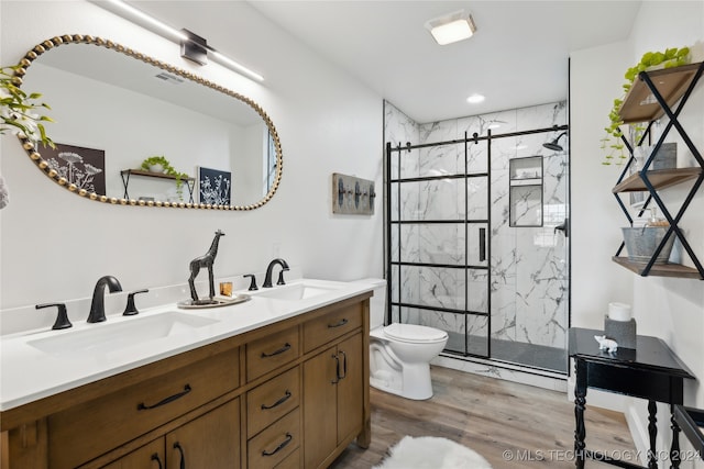 bathroom with double vanity, toilet, hardwood / wood-style floors, and an enclosed shower