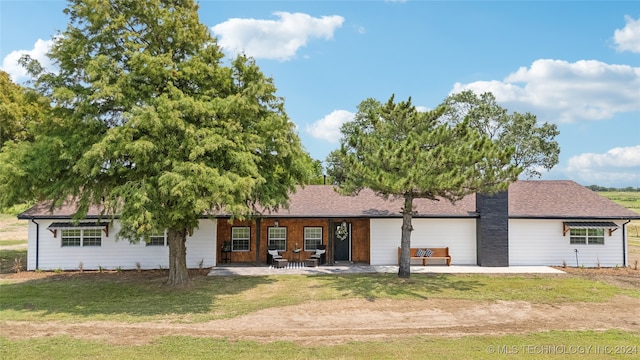 view of front of house featuring a patio and a front lawn