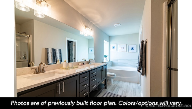 bathroom featuring double vanity, visible vents, a sink, and a bath