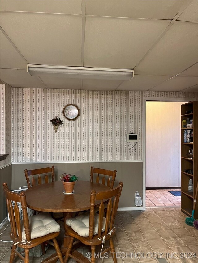 dining room featuring a paneled ceiling and tile patterned floors