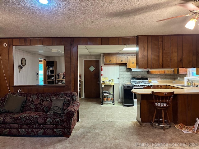 kitchen featuring a ceiling fan, light countertops, extractor fan, and a sink