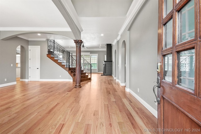 foyer with decorative columns, crown molding, and light hardwood / wood-style flooring