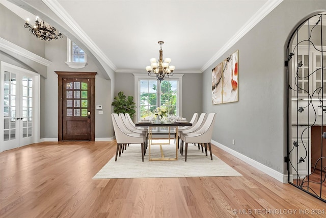 dining room featuring light hardwood / wood-style floors, ornamental molding, french doors, and a chandelier