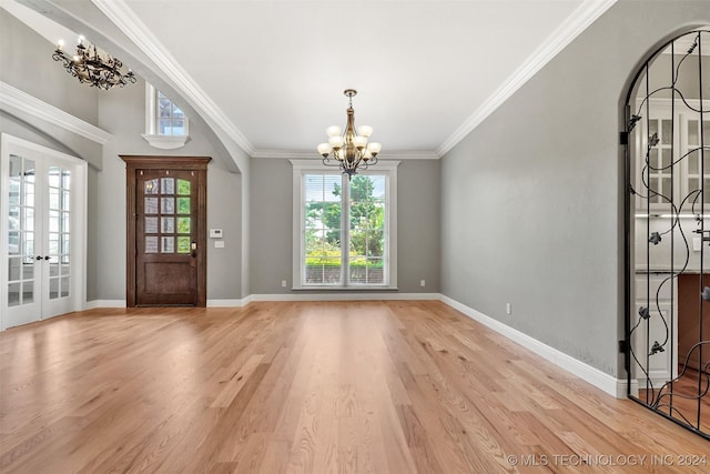 foyer featuring ornamental molding, light hardwood / wood-style floors, french doors, and an inviting chandelier