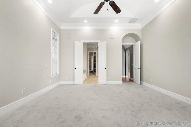 unfurnished bedroom with ceiling fan, light colored carpet, and crown molding